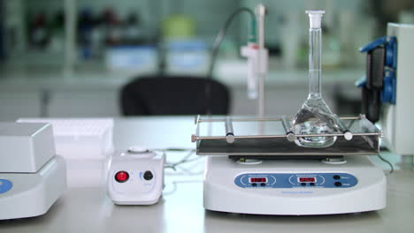 Laboratory-equipment-in-modern-lab.-Pure-liquid-mixing-in-glass-flask